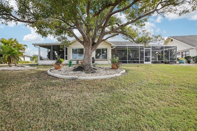 rear view of house with a lanai and a yard