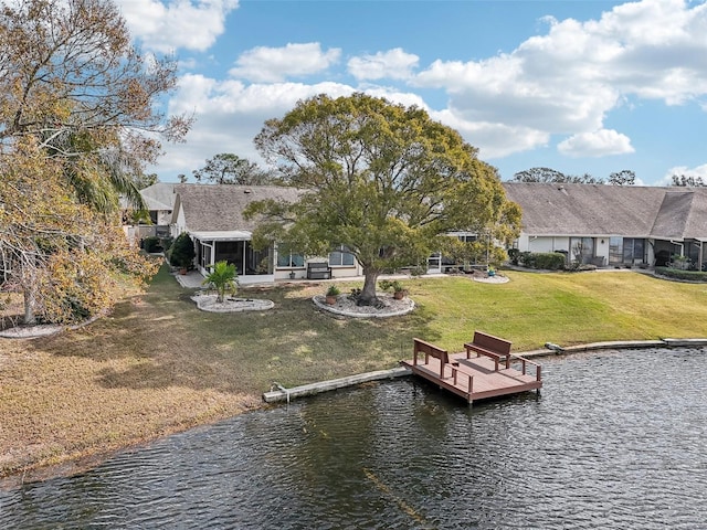 view of dock featuring a water view and a yard