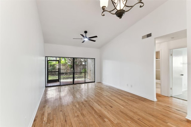 unfurnished room featuring high vaulted ceiling, ceiling fan with notable chandelier, and light hardwood / wood-style flooring