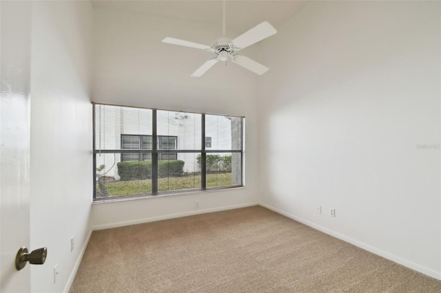 carpeted spare room featuring ceiling fan