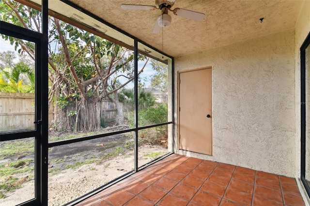 unfurnished sunroom with ceiling fan