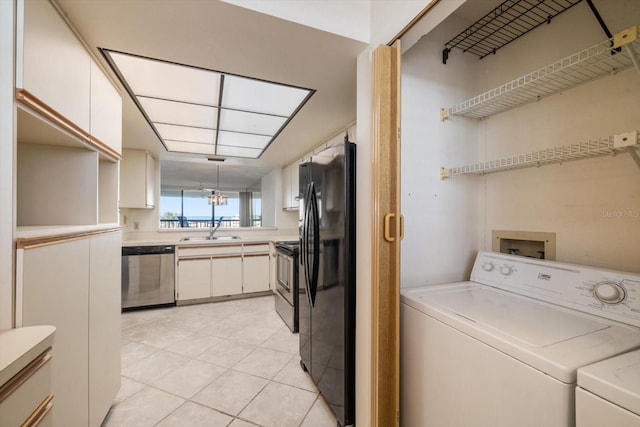 laundry room with independent washer and dryer, sink, and light tile patterned floors