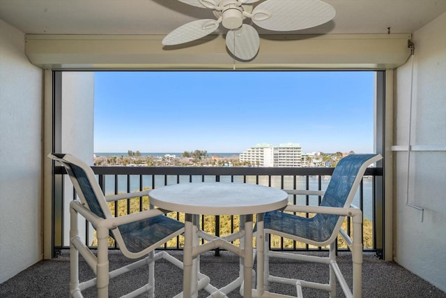 balcony featuring a water view and ceiling fan