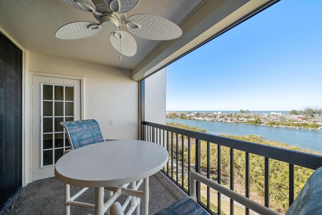 balcony with a water view and ceiling fan