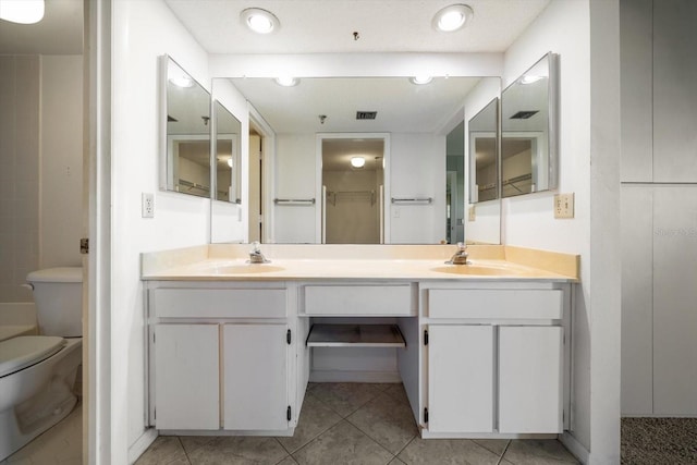 bathroom with tile patterned flooring, vanity, and toilet