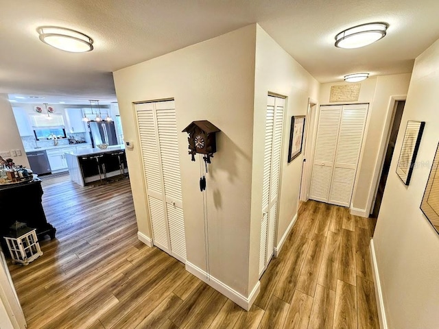 hallway featuring wood-type flooring and a textured ceiling