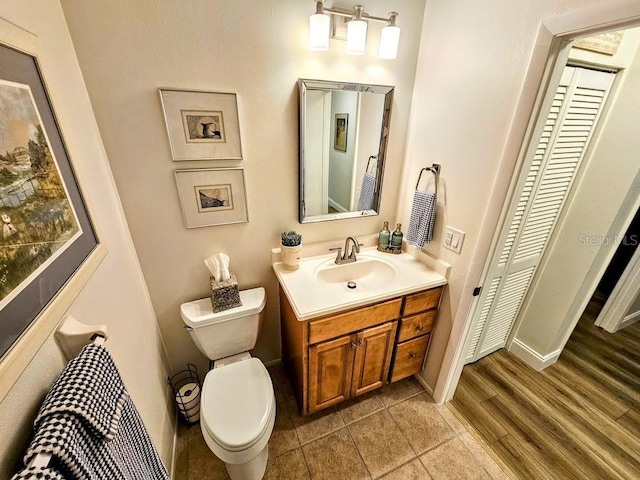 bathroom featuring vanity, toilet, and hardwood / wood-style floors