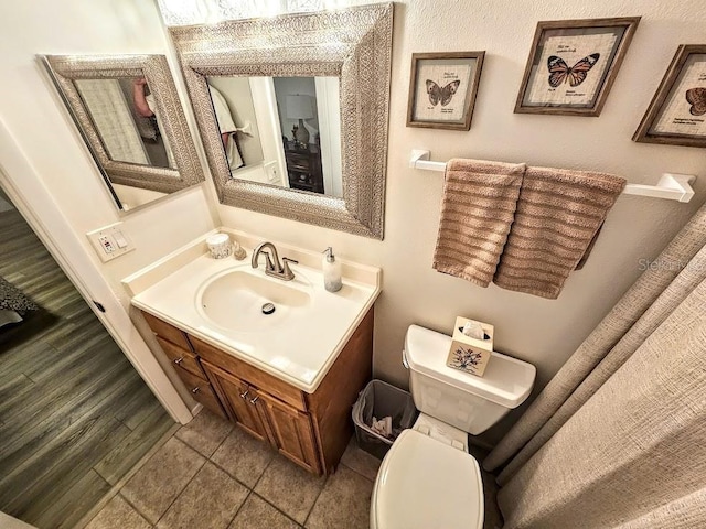 bathroom featuring vanity, wood-type flooring, and toilet