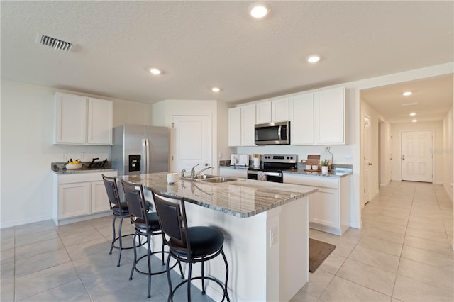 kitchen featuring white cabinetry, appliances with stainless steel finishes, sink, and a kitchen island with sink