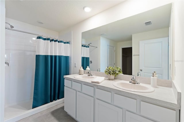 bathroom with a shower with curtain, vanity, tile patterned flooring, and a textured ceiling