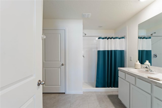 bathroom with vanity, tile patterned flooring, a shower with shower curtain, and a textured ceiling