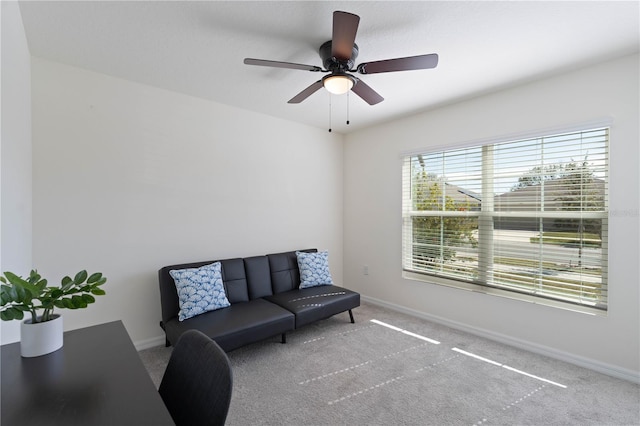 living area with ceiling fan and carpet