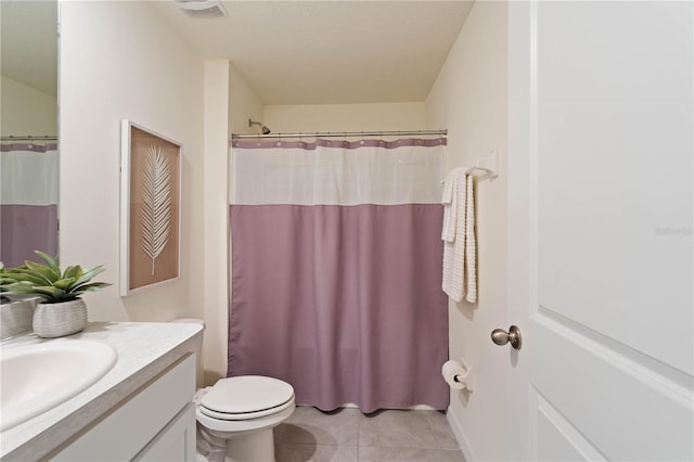 bathroom featuring tile patterned flooring, vanity, toilet, and walk in shower