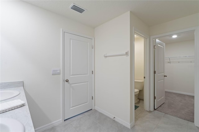 bathroom with vanity, tile patterned flooring, and toilet