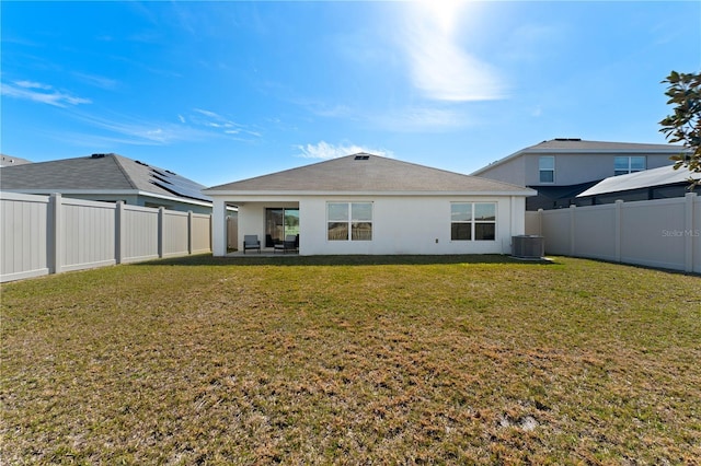 rear view of property with a yard and central air condition unit