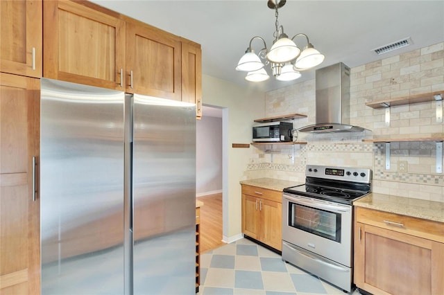 kitchen featuring backsplash, hanging light fixtures, stainless steel appliances, light stone countertops, and wall chimney exhaust hood