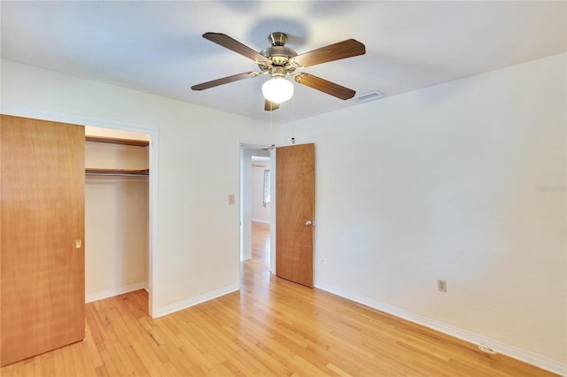 unfurnished bedroom featuring ceiling fan, a closet, and light wood-type flooring