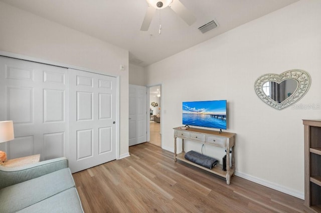 living area with light hardwood / wood-style floors and ceiling fan