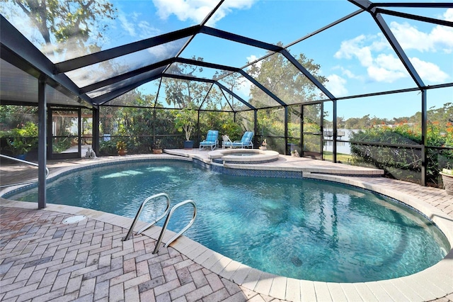 view of pool with a lanai, a patio area, and an in ground hot tub