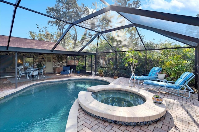 view of swimming pool with an in ground hot tub, glass enclosure, and a patio area