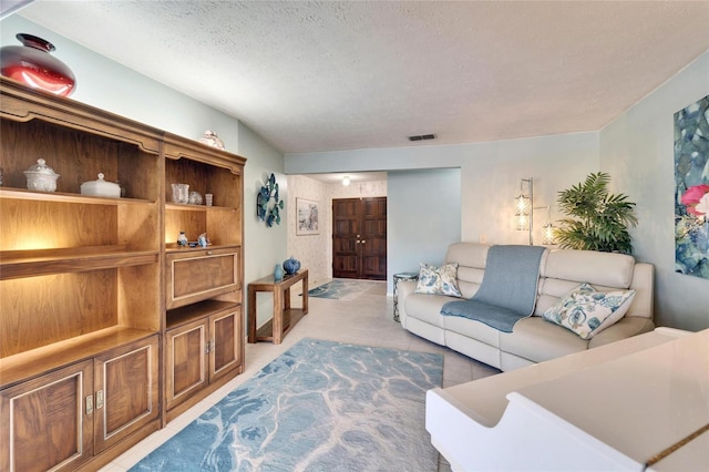 living area with light tile patterned floors, visible vents, and a textured ceiling