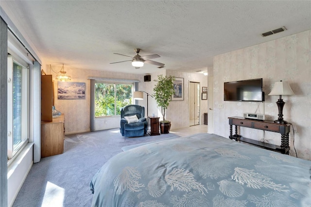 carpeted bedroom with a textured ceiling and ceiling fan