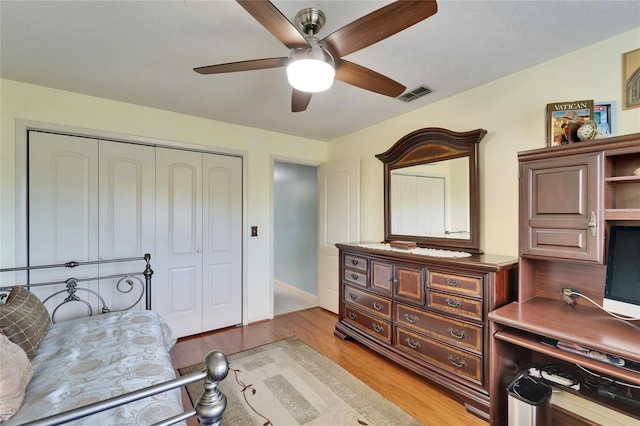 bedroom featuring light hardwood / wood-style floors, ceiling fan, and a closet