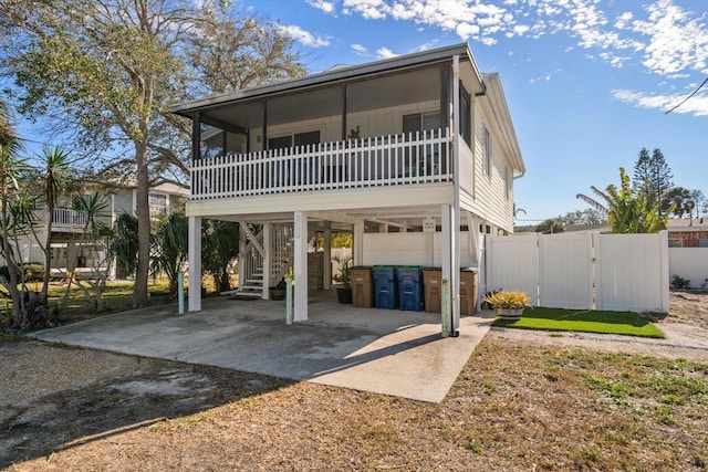 back of property with a carport and a sunroom