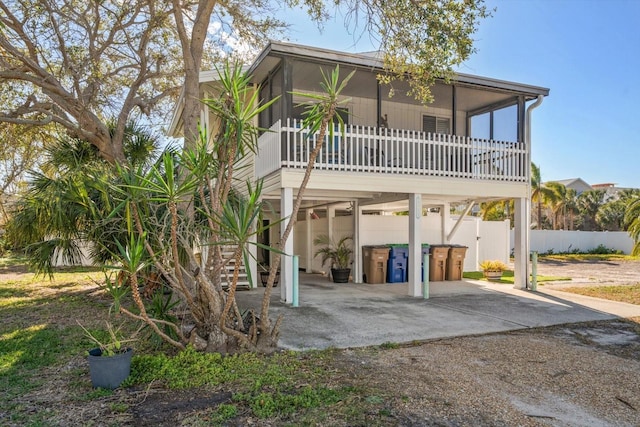 rear view of house featuring a sunroom and a patio area