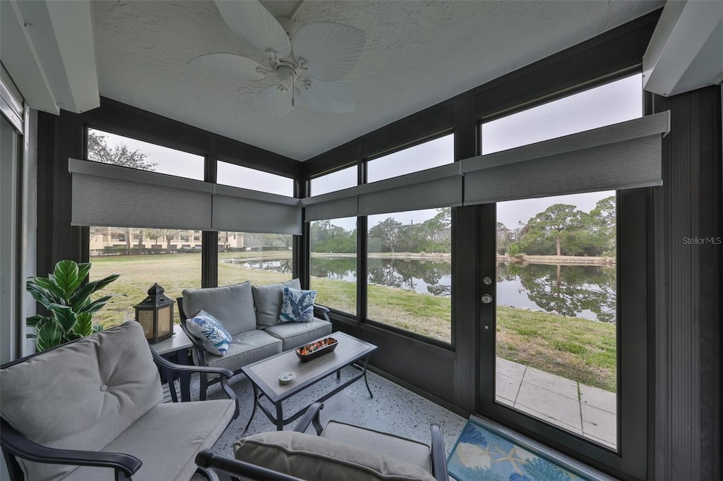 sunroom / solarium with a water view and ceiling fan