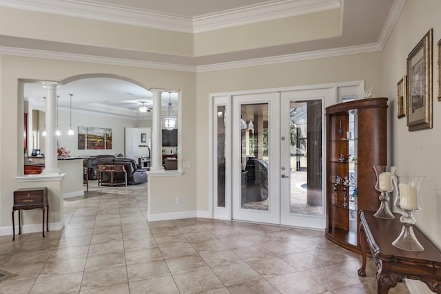 tiled foyer with french doors, decorative columns, and a tray ceiling