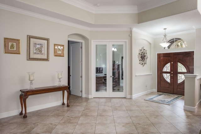 foyer with french doors, crown molding, a raised ceiling, and light tile patterned flooring