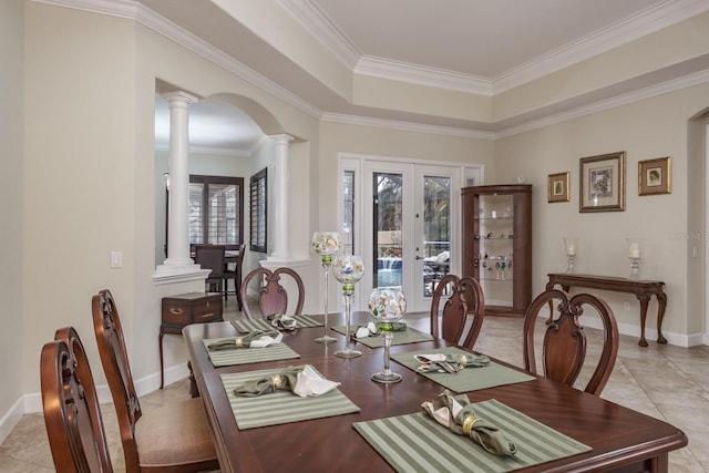 dining space with decorative columns, a raised ceiling, ornamental molding, and light tile patterned floors