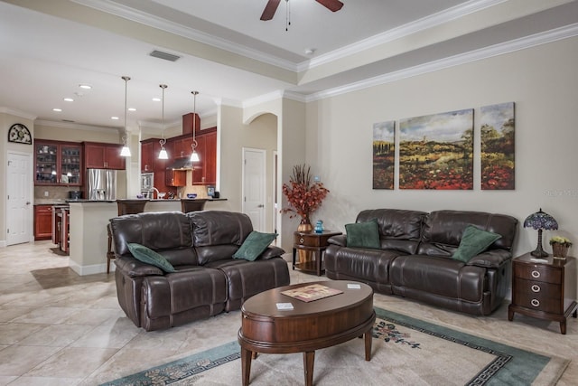 living room with ceiling fan, ornamental molding, and light tile patterned floors