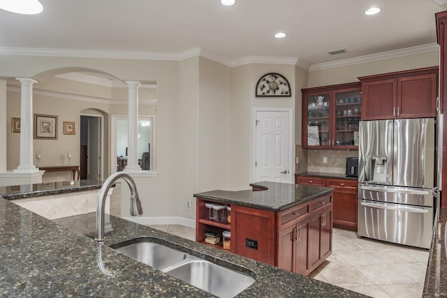 kitchen featuring sink, crown molding, decorative columns, a kitchen island, and stainless steel fridge with ice dispenser