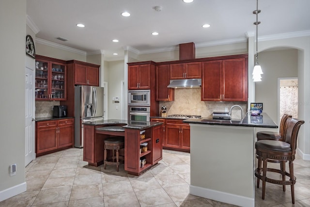 kitchen featuring tasteful backsplash, ornamental molding, appliances with stainless steel finishes, and hanging light fixtures