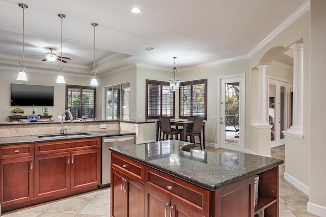 kitchen with sink, decorative columns, a center island, stainless steel dishwasher, and dark stone counters