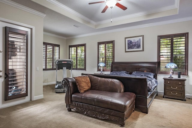 carpeted bedroom with crown molding, ceiling fan, and a raised ceiling