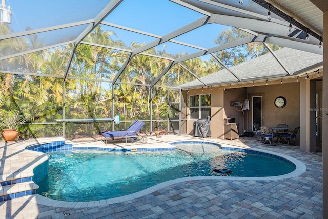 view of swimming pool featuring a patio and glass enclosure