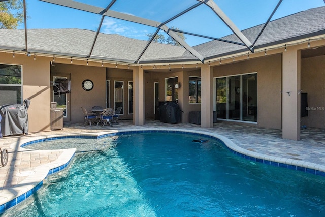 view of swimming pool with a lanai and a patio