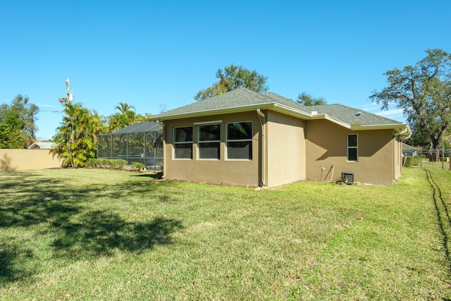 rear view of property featuring a yard and a lanai