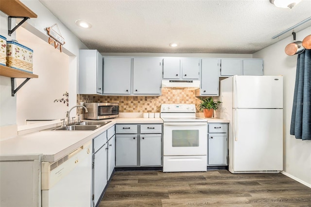 kitchen featuring dark hardwood / wood-style flooring, sink, white appliances, and tasteful backsplash