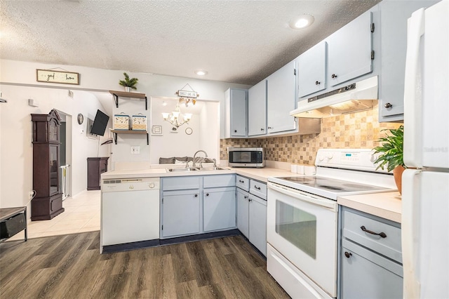 kitchen featuring white appliances, dark hardwood / wood-style flooring, sink, and decorative backsplash