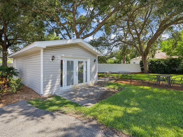 back of property featuring a yard, an outdoor structure, and a patio