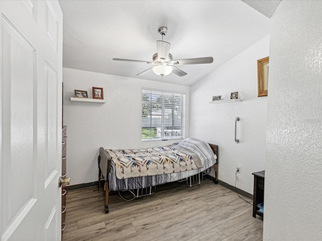 bedroom with lofted ceiling, ceiling fan, and light wood-type flooring