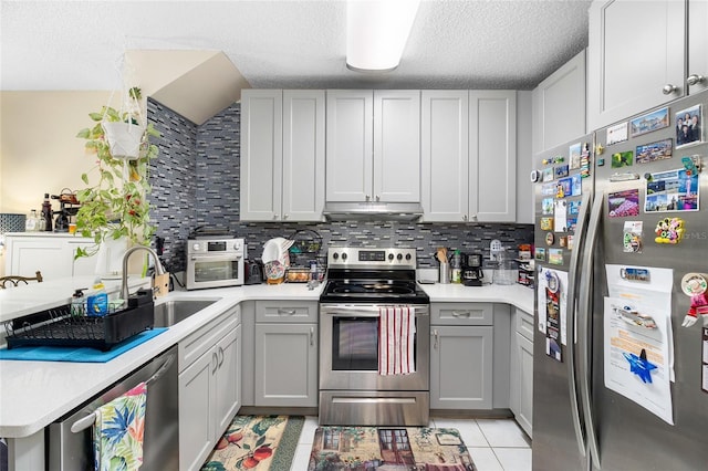 kitchen featuring stainless steel appliances, sink, and gray cabinetry