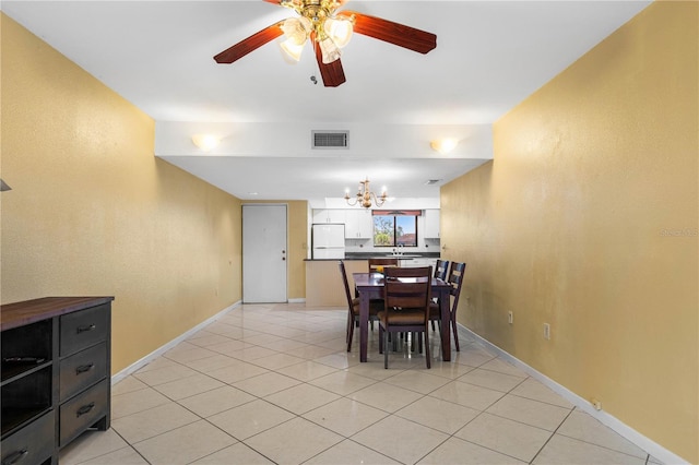 tiled dining space with ceiling fan with notable chandelier