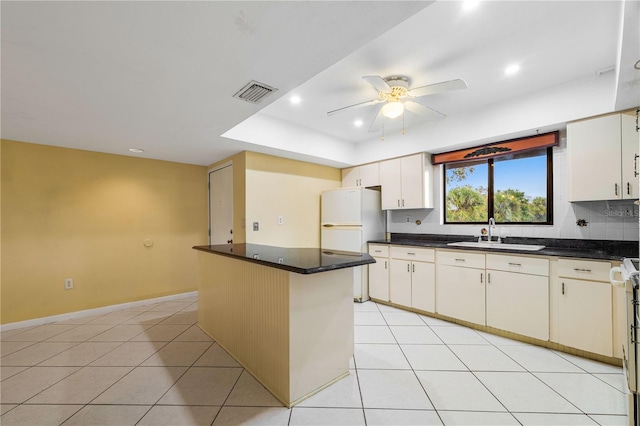 kitchen with sink, ceiling fan, a kitchen island, light tile patterned flooring, and white fridge