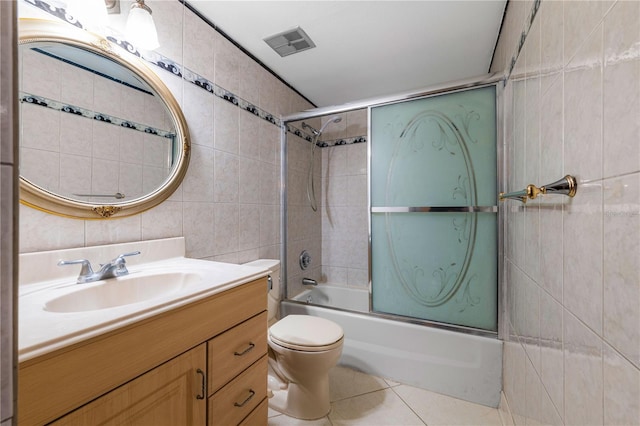 full bathroom featuring tile patterned floors, toilet, shower / bath combination with glass door, tile walls, and vanity