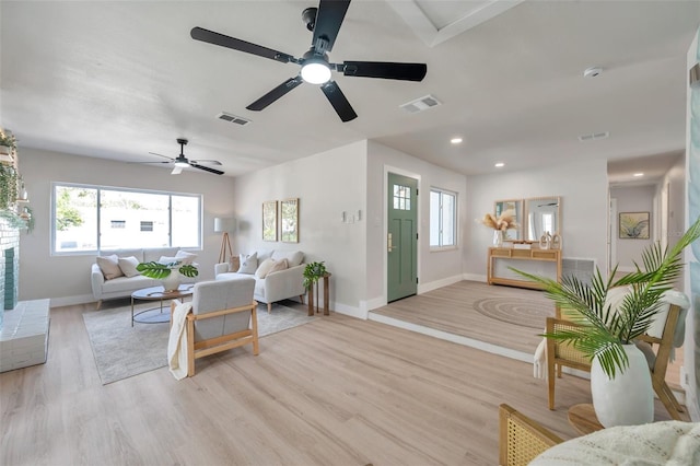 living room with light wood-type flooring, a healthy amount of sunlight, and visible vents